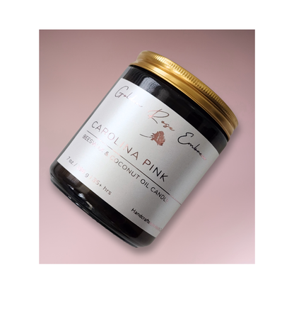 Carolina Pink 7oz Beeswax Candle. Amber glass jar. Gold metal lid. Cotton wick. 
An enchanting aroma of rosy pink peony, green foliage, and a touch of spice. This floral fragrance will uplift and calm your senses. 