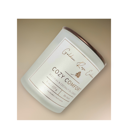 Cozy Comfort 8oz Beeswax Candle. Frosted glass jar, bronze metallic lid, and woodwick. 
Notes of Bergamot, Mahogany, and Musk. 
Create a warm and cozy atmosphere with the aroma of flannel, bergamot, mahogany, and musk. This fragrance will envelope you in comfort. 