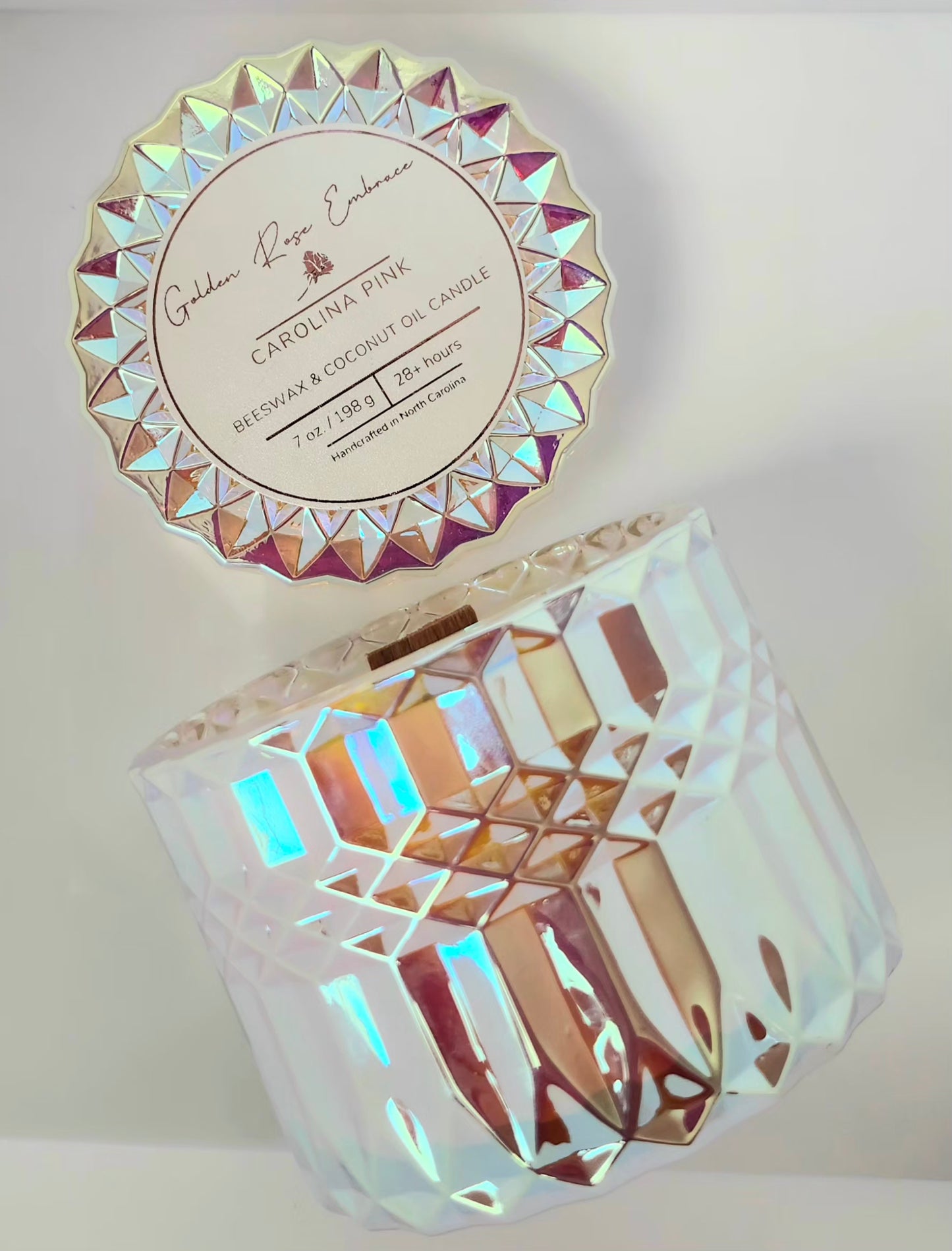 Carolina Pink 7 oz beeswax candles, pink iridescent posh glass jar, woodwick candles, aroma of rosy pink peony, green foliage, and a touch of spice, side view. 