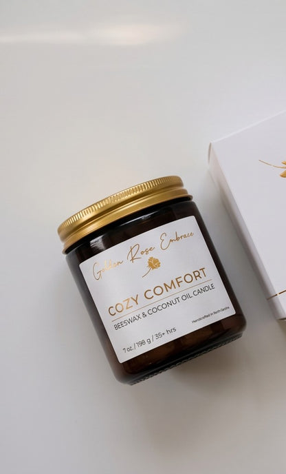 Cozy Comfort 7oz Beeswax Candle. Amber glass jar, gold lid, and woodwick. 
Notes of Bergamot, Mahogany, and Musk
Create a warm and cozy atmosphere with the aroma of flannel, bergamot, mahogany, and musk. This fragrance will envelope you in comfort. 