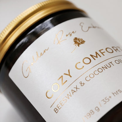 Cozy Comfort 7oz Beeswax Candle. Amber glass jar, gold lid, and woodwick. 
Notes of Bergamot, Mahogany, and Musk
Create a warm and cozy atmosphere with the aroma of flannel, bergamot, mahogany, and musk. This fragrance will envelope you in comfort. 